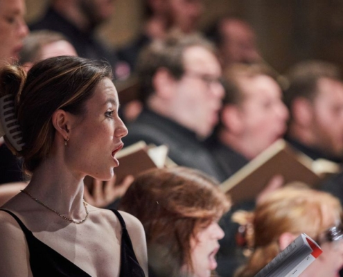 Profil;e shot of a singer performing with the Festival Voices.